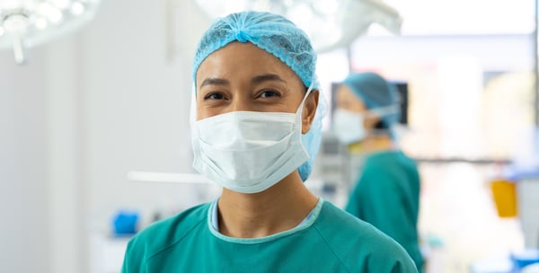 portrait-of-smiling-biracial-female-surgeon-in-mas-2023-11-27-04-57-51-utc